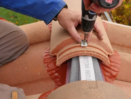 La pose des tuiles faîtières